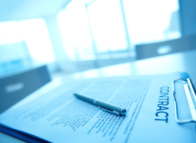 Image of business contract and pen on table