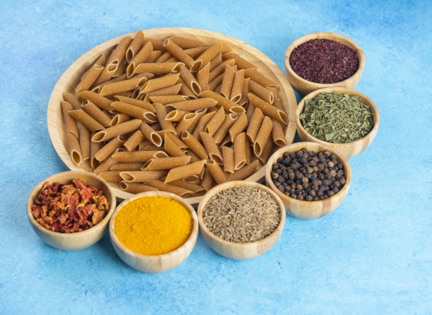 Close up photo of Raw brown past on wooden board and various kinds of spices over blue background. High quality photo